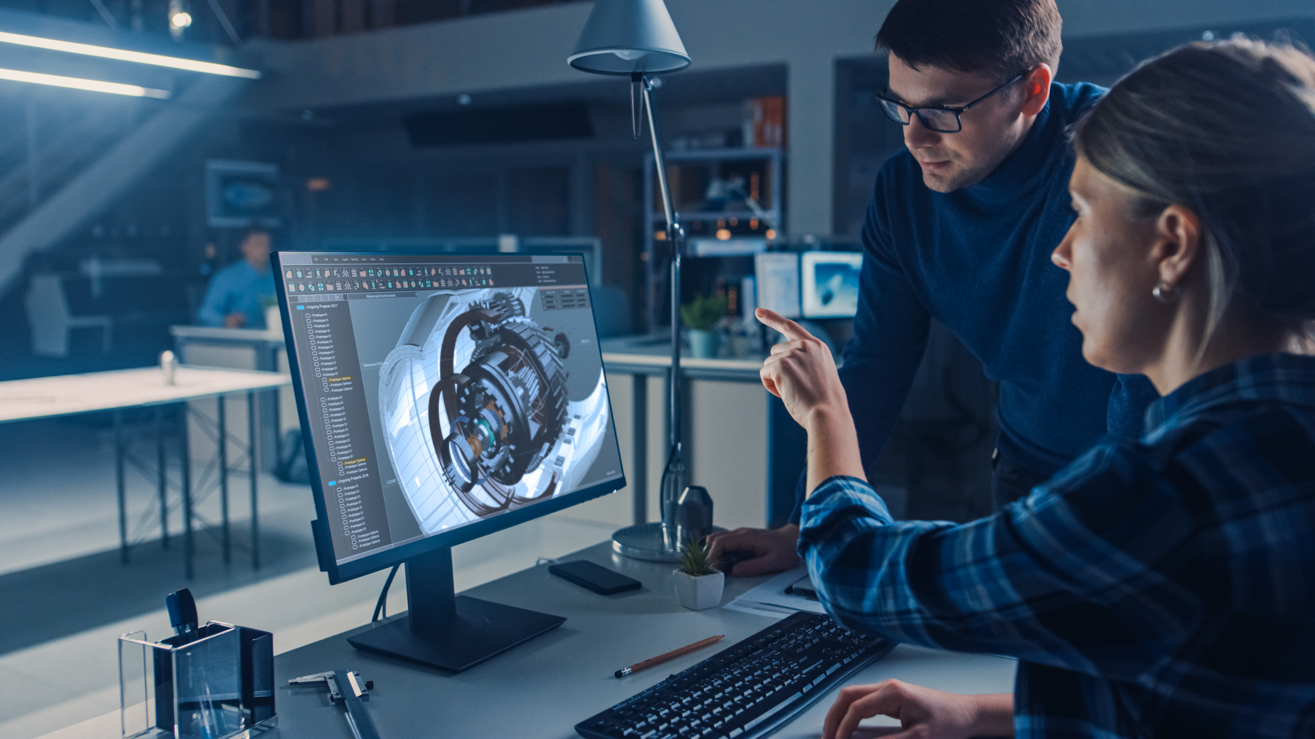 Two engineers evaluate a 3D design.