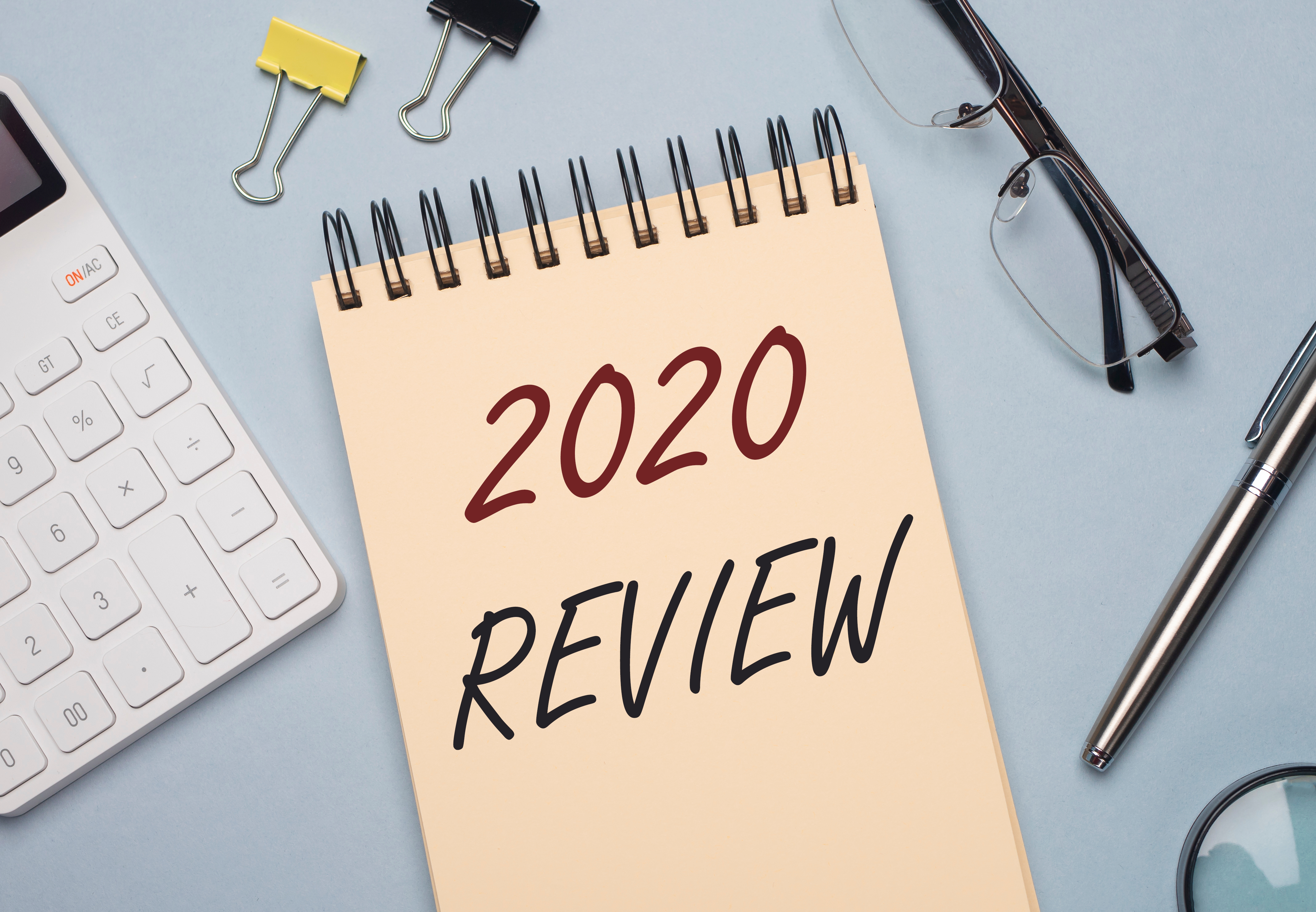 2020 review, written on a notepad and surrounded by office supplies.