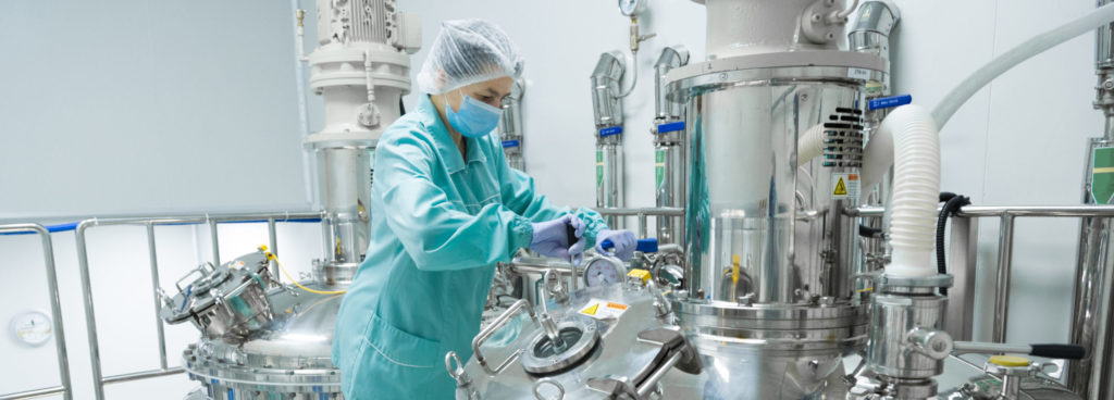 Pharmaceutical factory worker in a cleanroom environment.