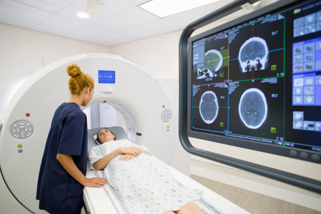Radiographer talks with a patient before a CT scan