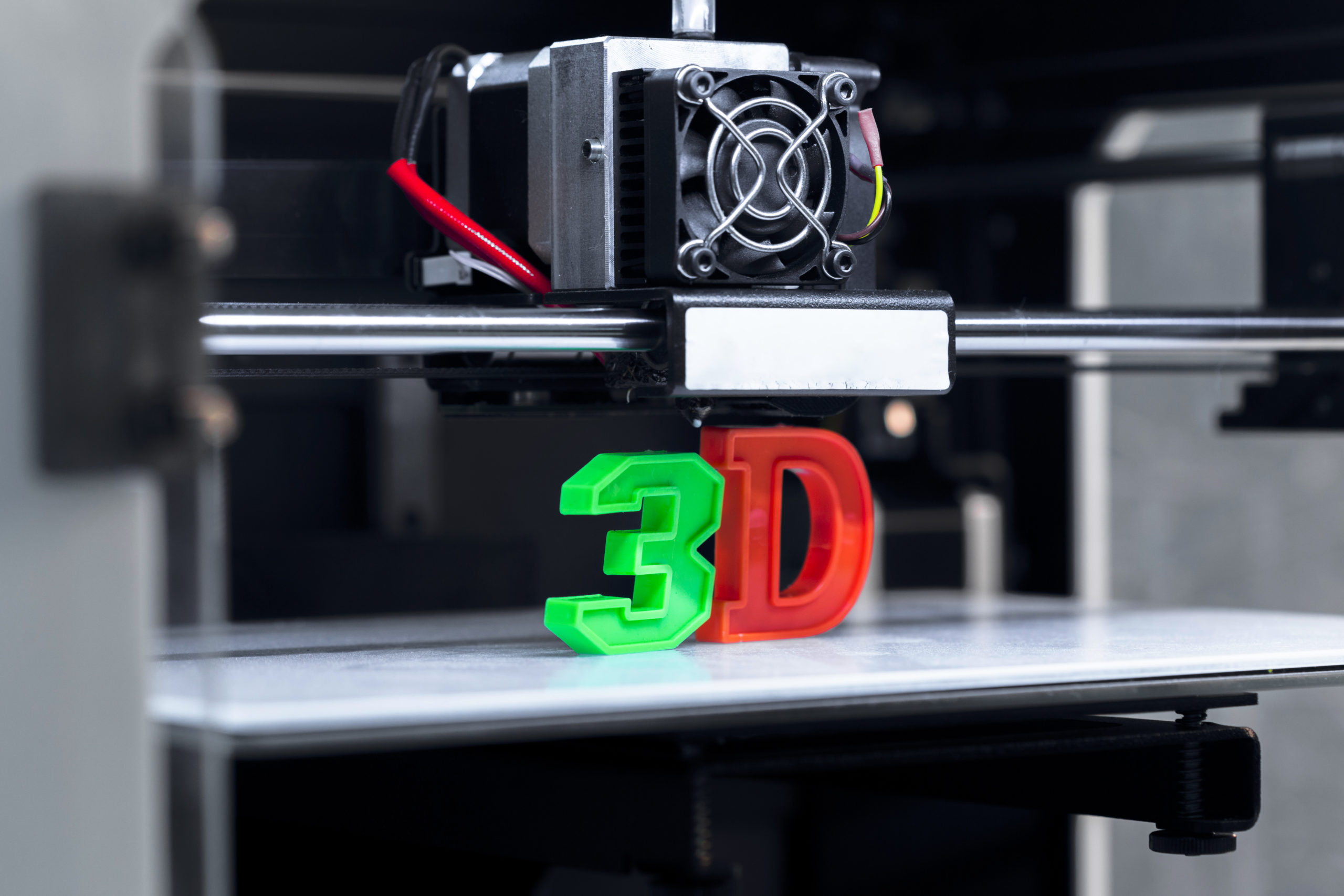 Image of the word 3D being printed, with the “3e” in green and the “D” in red.