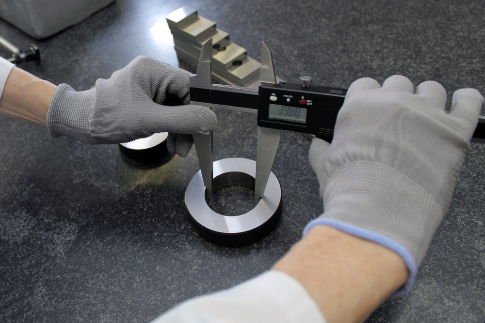 A person measuring a part using calipers